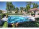 Sparkling community pool and spa with lounge chairs, lush green landscaping, and clear blue skies at 8136 E Cortez Dr, Scottsdale, AZ 85260