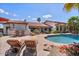 Relaxing backyard pool with patio furniture, lush plants, and desert landscaping at 8514 E Country Club Trl, Scottsdale, AZ 85255