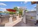Outdoor kitchen with a grill, privacy fence, and outdoor shower at 8514 E Country Club Trl, Scottsdale, AZ 85255