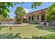 Lush backyard with a putting green, pool, patio and verdant landscaping at 8514 E Country Club Trl, Scottsdale, AZ 85255