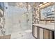 Elegant bathroom with a glass-enclosed shower, decorative wallpaper, and stylish vanity at 8514 E Country Club Trl, Scottsdale, AZ 85255