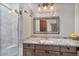 Stylish bathroom showcases a vanity with granite counters, a framed mirror, and a glass-enclosed shower at 8514 E Country Club Trl, Scottsdale, AZ 85255