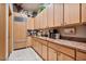 Well-equipped kitchenette with natural wood cabinetry, a built-in refrigerator, and modern appliances at 8514 E Country Club Trl, Scottsdale, AZ 85255