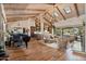 Spacious living room with high ceilings, wood beams, hardwood floors, and abundant natural light at 8514 E Country Club Trl, Scottsdale, AZ 85255