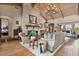 Comfortable living room with vaulted ceilings, hardwood floors, fireplace, and large windows at 8514 E Country Club Trl, Scottsdale, AZ 85255