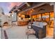 Cozy outdoor living space with built-in fireplace, bar area, and comfortable wicker furniture at 8514 E Country Club Trl, Scottsdale, AZ 85255