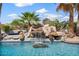Close-up of a backyard pool featuring a stunning rock waterfall detail at 8514 E Country Club Trl, Scottsdale, AZ 85255