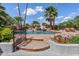 Beautiful pool with rock waterfall feature, surrounded by lush landscaping and palm trees at 8514 E Country Club Trl, Scottsdale, AZ 85255