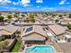 Aerial view showing a backyard pool, solar panels, patio, and desert landscaping in a residential neighborhood at 8657 E Capri Ave, Mesa, AZ 85208
