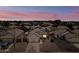 Twilight aerial view showcases a residential neighborhood with a backyard pool and solar panels on a home at 8657 E Capri Ave, Mesa, AZ 85208