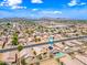 Wide aerial shot showcasing a neighborhood with community amenities and mountain views in the distance at 8657 E Capri Ave, Mesa, AZ 85208