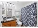 Cozy bathroom featuring a granite countertop, patterned shower curtain, and ample shelving for storage at 8657 E Capri Ave, Mesa, AZ 85208