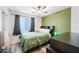 Cozy bedroom featuring a green accent wall, a ceiling fan and a window at 8657 E Capri Ave, Mesa, AZ 85208