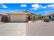 Charming single-story home featuring stone accents, a two-car garage, and low-maintenance landscaping at 8657 E Capri Ave, Mesa, AZ 85208