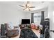Living room with a ceiling fan, window, and a large television at 8657 E Capri Ave, Mesa, AZ 85208
