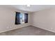 Carpeted bedroom with neutral paint, and window with dark curtains at 9026 W Cambridge Ave, Phoenix, AZ 85037
