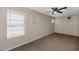 Comfortable bedroom with plush carpeting, fan and bright, sunny window at 9026 W Cambridge Ave, Phoenix, AZ 85037
