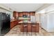 Functional kitchen with wood cabinets, an island with seating, and modern appliances at 9026 W Cambridge Ave, Phoenix, AZ 85037