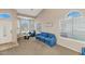 Bright living room with a vaulted ceiling, tiled entry, and plush blue furnishings at 9026 W Cambridge Ave, Phoenix, AZ 85037