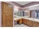 Vanity with a lot of cabinets, drawers, and mirrors under bright lighting in an interior shot of the bathroom at 9512 W Mcrae Way, Peoria, AZ 85382
