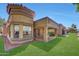Charming home exterior featuring a tiled roof, manicured lawn, and covered patio with seating area at 9512 W Mcrae Way, Peoria, AZ 85382