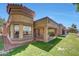 Charming home exterior featuring a tiled roof, manicured lawn, and covered patio with seating area at 9512 W Mcrae Way, Peoria, AZ 85382
