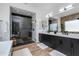 Beautiful bathroom featuring double vanities, a soaking tub, and a glass-enclosed shower with herringbone tile at 100 W Northern Ave # 8, Phoenix, AZ 85021