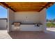 An outdoor community grill station featuring granite countertops and stainless steel appliances beneath a wood beamed roof structure at 100 W Northern Ave # 8, Phoenix, AZ 85021