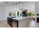 A modern kitchen features an island with a white countertop and dark wood cabinets in an open-concept space at 100 W Northern Ave # 8, Phoenix, AZ 85021