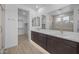 Bright bathroom featuring double sinks with quartz countertops, modern cabinets, and a walk-in shower at 10224 E Utah Ave, Mesa, AZ 85212