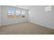Empty bedroom with neutral carpet, white walls, and ample natural light from multiple windows at 10224 E Utah Ave, Mesa, AZ 85212