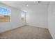 Bright bedroom with a neutral carpet and three windows overlooking green apartments at 10224 E Utah Ave, Mesa, AZ 85212