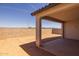 A covered patio providing a shaded area with views of the backyard and the desert landscape beyond at 10224 E Utah Ave, Mesa, AZ 85212