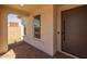 Close-up of the home's entrance showing a modern door, stucco walls, and tile flooring at 10224 E Utah Ave, Mesa, AZ 85212