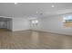 Vast, empty living area showcasing wood-like floors and natural light from multiple windows at 10224 E Utah Ave, Mesa, AZ 85212