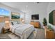 Inviting primary bedroom with a big bed, tv, and three windows allowing lots of natural light at 10224 E Utah Ave, Mesa, AZ 85212