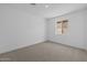 Unfurnished bedroom with plush carpeting and a large window that lets in natural light at 10230 E Utah Ave, Mesa, AZ 85212
