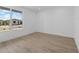 Bright, unfurnished bedroom with wood-look flooring and a large window with a neighborhood view at 10230 E Utah Ave, Mesa, AZ 85212