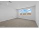 A neutral-toned room with three windows, carpeted floors, white walls and ceilings, and recessed lighting at 10230 E Utah Ave, Mesa, AZ 85212