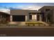Stylish modern home with clean lines, a dark garage door, and tasteful landscaping at dusk at 10230 E Utah Ave, Mesa, AZ 85212