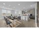 Modern kitchen and dining area featuring stainless steel appliances, white quartz counters, and a dining table with seating at 10230 E Utah Ave, Mesa, AZ 85212