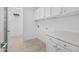 Well-lit laundry room has bright white walls and wooden floors. Includes counter and cabinet space at 10230 E Utah Ave, Mesa, AZ 85212
