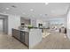 Bright, open-concept living space features a large island with quartz countertops, stainless steel appliances and comfortable seating at 10230 E Utah Ave, Mesa, AZ 85212