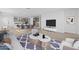 Open-concept living room with wood floors, a large rug, and stylish furniture leading into a modern kitchen at 10230 E Utah Ave, Mesa, AZ 85212