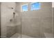 Contemporary glass-enclosed shower with tiled walls, neutral toned bench, and a rainfall shower head at 10230 E Utah Ave, Mesa, AZ 85212
