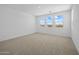 Unfurnished bedroom with carpet, bright natural lighting, and neighborhood views from several windows at 10236 E Utah Ave, Mesa, AZ 85212