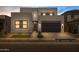Modern two-story home featuring a minimalist design, well-lit exterior, and a two-car garage at 10236 E Utah Ave, Mesa, AZ 85212