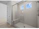 Bright shower featuring gray tiling, glass door, and a built-in bench at 10236 E Utah Ave, Mesa, AZ 85212