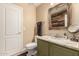 Well-lit bathroom featuring granite countertops, olive cabinetry, a decorative mirror, and elegant fixtures at 1043 N 90Th Cir, Mesa, AZ 85207