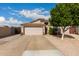 Traditional-style single-story home features a concrete driveway, tan stucco, and a two-car garage with direct entry at 1043 N 90Th Cir, Mesa, AZ 85207